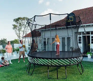 Load image into Gallery viewer, girl standing on a trampoline while her family is watching her