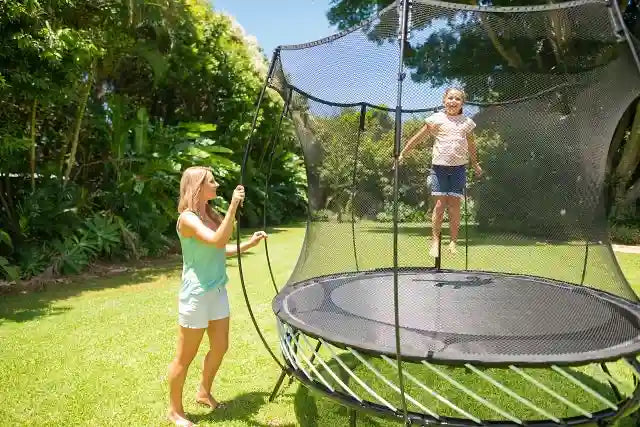 girl jumping on an outdoor trampoline