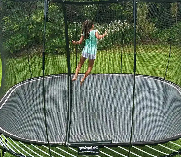 girl jumping on an outdoor trampoline