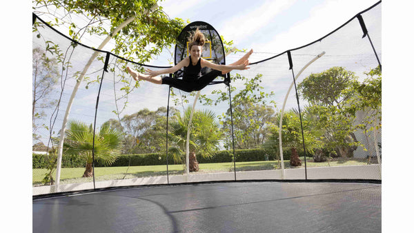 A woman jumping in mid-air on a Springfree Trampoline.