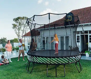 Load image into Gallery viewer, girl standing on a trampoline while her family is watching her
