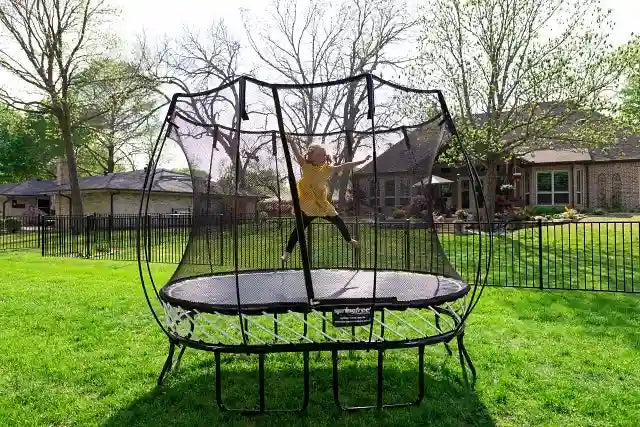 girl jumping on an outdoor trampoline