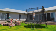 Load image into Gallery viewer, girl jumping on a trampoline with other kids watching him
