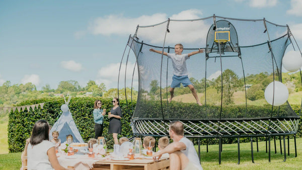 boy jumping on a trampoline in a picnic park
