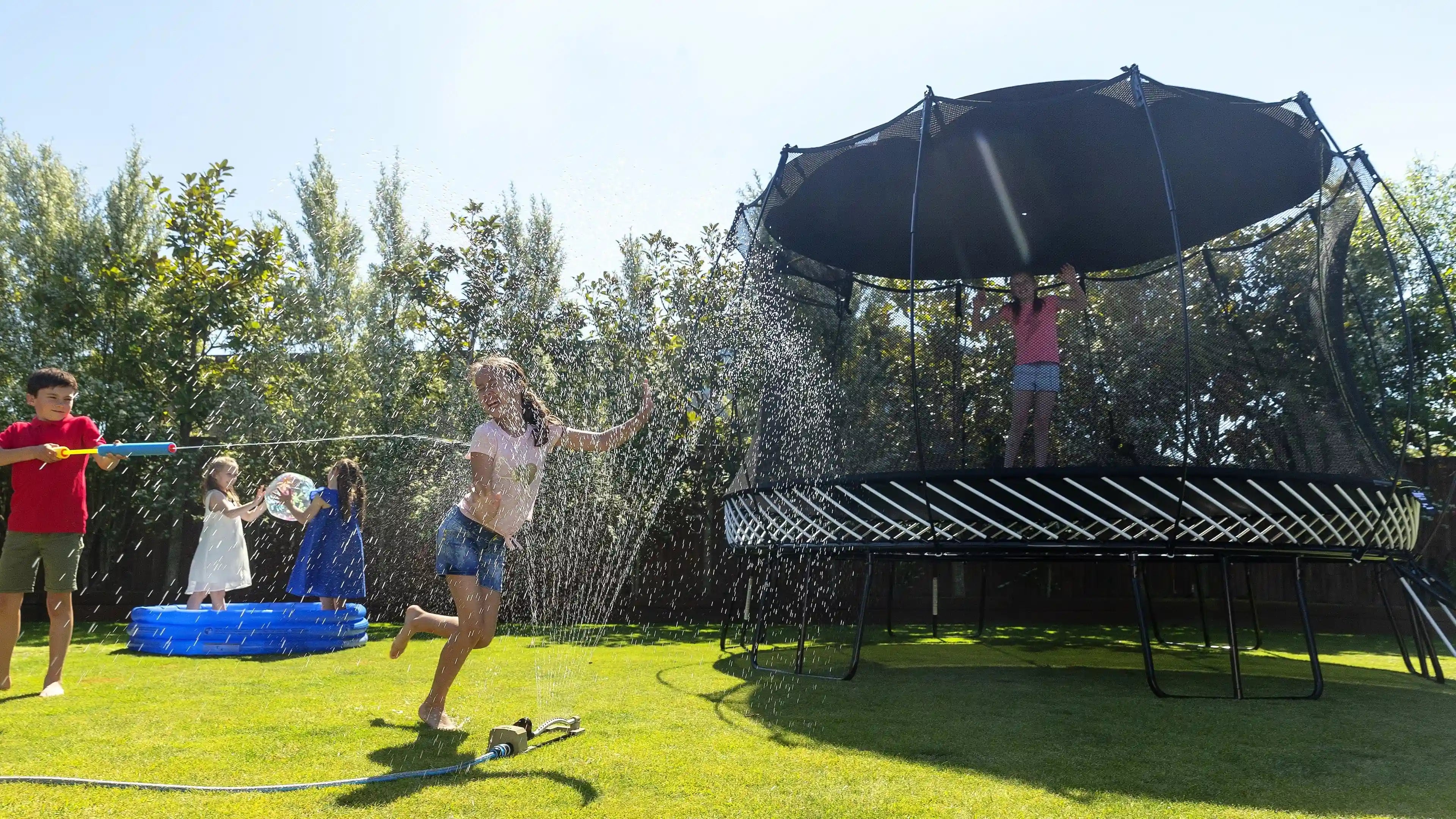 girl playing on a trampoline with a sun shade