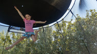 Load image into Gallery viewer, girl jumping on a trampoline with a sun shade
