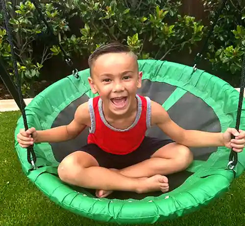 kid sitting on a tree swing