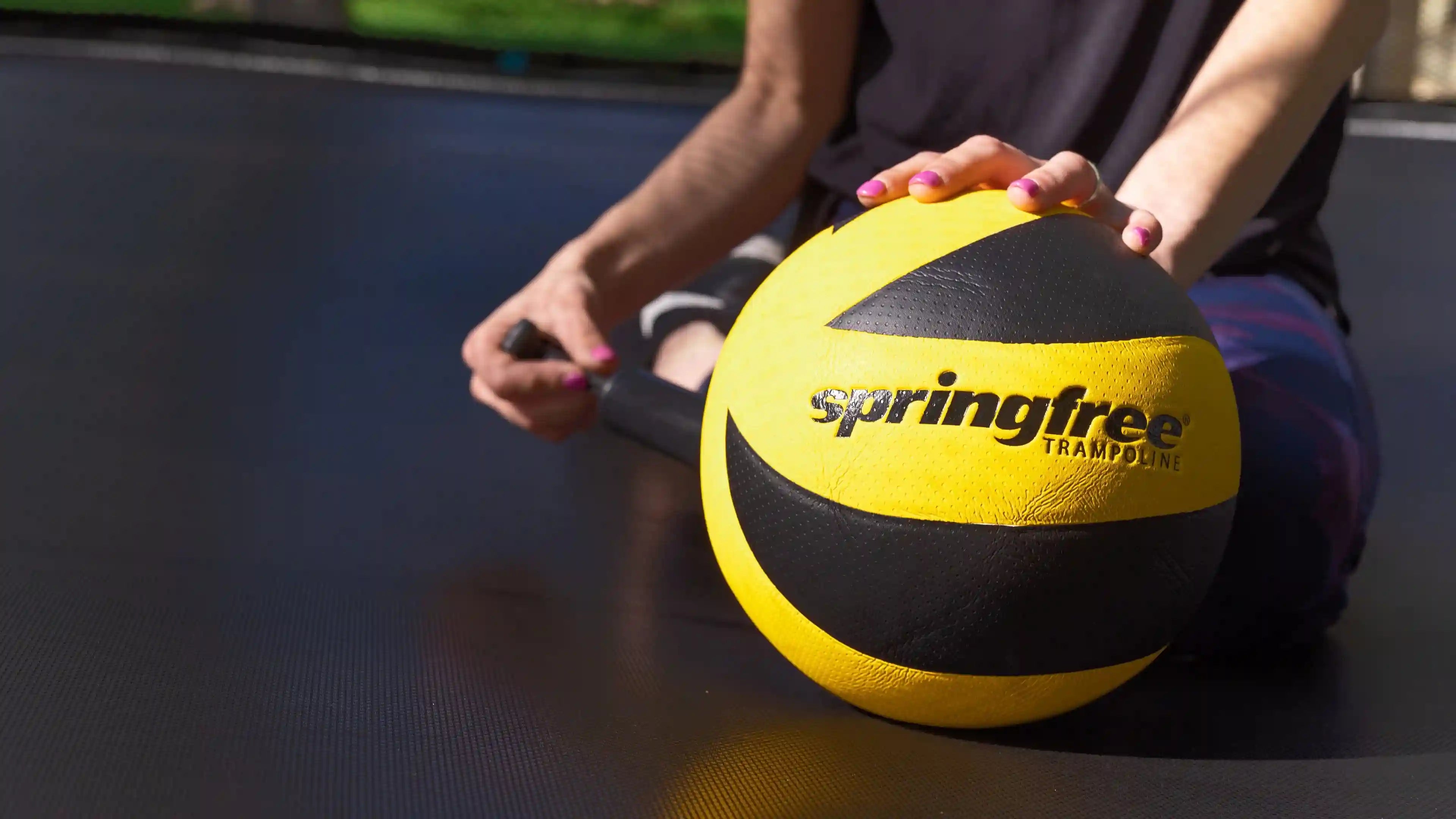 lady pumping the springfree trampoline ball